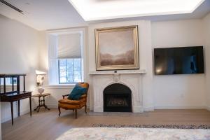 a living room with a fireplace and a tv at Treadwell Mansion in Portsmouth
