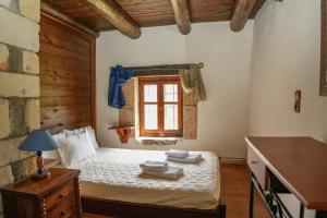 a bedroom with a bed and a window with towels on it at Traditional Villa with pool in Sfakia in Ímbros +30 photos
