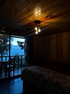 a bedroom with a bed and a table and a window at Cabaña OLIN in San Mateo Río Hondo