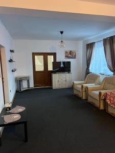 a living room with a couch and a tv at Vila Maria in Roman +3 photos