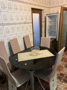 a dining room table with chairs and a glass bowl on it at Vila Maria in Roman