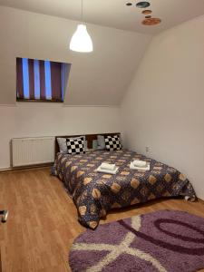 a bedroom with a bed with a comforter and a rug at Vila Maria in Roman