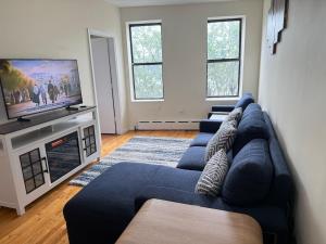 a living room with a blue couch and a tv at Weehawken Apartment NYC Skyline in Weehawken