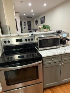 a kitchen with stainless steel appliances and a counter top at Weehawken Apartment NYC Skyline in Weehawken