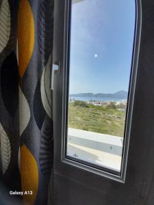 a window in a room with a view of the ocean at Overhill Apartments Adamas in Adamantas