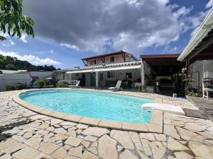 a swimming pool in front of a house at Villa Soleïa in Gourbeyre
