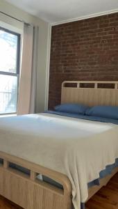 a bed in a room with a brick wall at Weehawken Apartment NYC Skyline in Weehawken