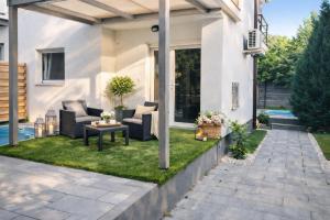 a patio with couches and a table on the grass at Happy Home Apartman in Siófok
