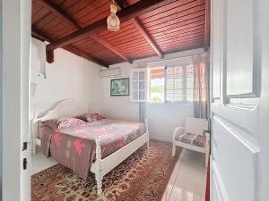 a bedroom with a bed and a window at Villa Soleïa in Gourbeyre +12 photos