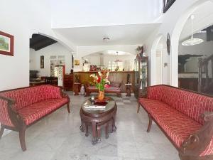 a living room with red couches and a table at Villa Soleïa in Gourbeyre