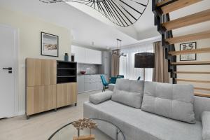 a living room with a couch and a kitchen at Silarent Niechorze Parkowa 3 in Niechorze