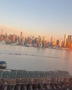 a view of a city with a river and buildings at Weehawken Apartment NYC Skyline in Weehawken