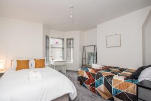 a bedroom with a bed and a chair in it at Modern 4 Bedroom House Sleeps 10 Free Parking Liverpool in Litherland