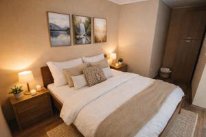 a bedroom with a large white bed with two lamps at Happy Home Apartman in Siófok +25 photos