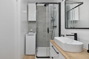 a white bathroom with a sink and a shower at Silarent Niechorze Parkowa 3 in Niechorze +54 photos