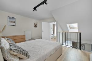 a bedroom with white walls and a large bed at Silarent Niechorze Parkowa 3 in Niechorze