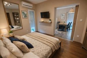 a bedroom with a large bed and a dining room at Happy Home Apartman in Siófok