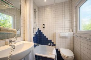 a bathroom with a sink and a toilet and a tub at Airport Messe Villa Casa in Düsseldorf