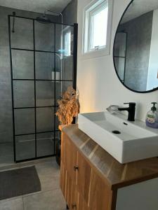 a bathroom with a white sink and a shower at Oasen in Nørresundby +2 photos