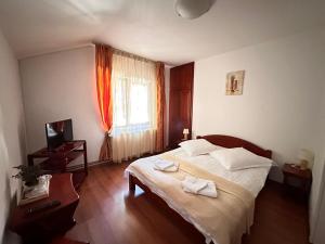 a bedroom with a bed with two towels on it at Raza Soarelui in Moieciu de Sus