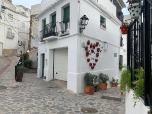 a white building with a heart on the side of it at Hostel Los Guajares in Guájar-Faragüit