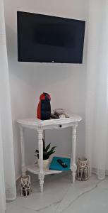 a white table with a television on a wall at Enalios House in Vourvoúlos