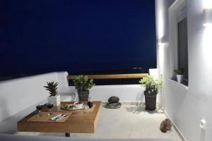 a room with a table on a balcony at Enalios House in Vourvoúlos