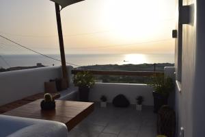 a balcony with a view of the ocean at sunset at Enalios House in Vourvoúlos
