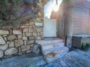 a cat is standing next to a stone building at Kritamos Beach House - Near the Beach with Easy Parking in Matala