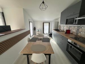 a kitchen with a table and chairs in a room at Appartement terrasse en ville in Blois