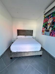 a bedroom with a bed and a painting on the wall at Casa tequila in Nueva Gorgona