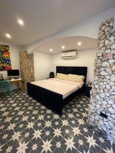 a bedroom with a bed and a stone wall at Casa tequila in Nueva Gorgona
