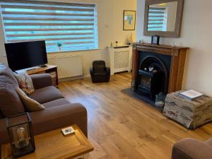 a living room with a couch and a fireplace at Jacuma in Rhosneigr