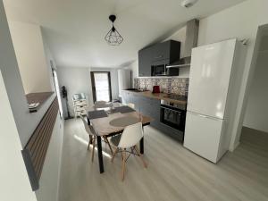 a kitchen with a table and a white refrigerator at Appartement terrasse en ville in Blois +14 photos