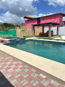 a swimming pool in front of a red building at Casa tequila in Nueva Gorgona