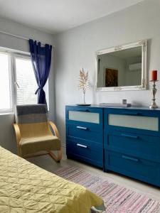 a bedroom with a blue dresser and a mirror at Vila 'Anna' in Krapets