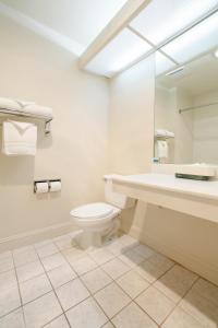 a bathroom with a sink toilet and a mirror at The Monarch Resort in Pacific Grove +13 photos