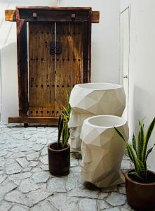 a bathroom with a toilet and two potted plants at Kundera Hotel Boutique in Colima