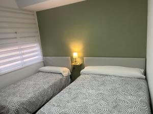 two beds sitting next to each other in a bedroom at Apartamento Terraza a la Almadraba in Barbate +21 photos