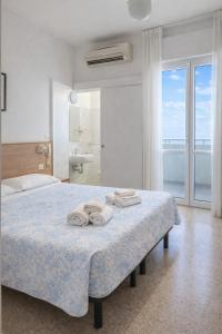 a bedroom with a bed with two towels on it at Hotel Brezza Nuova Gestione in Rimini
