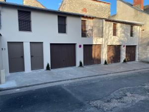 a white building with four garage doors on a street at Appartement terrasse en ville in Blois
