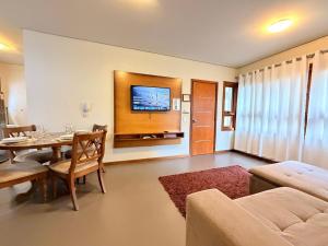 a living room with a table and a dining room at Apto Rua Coberta Gramado in Gramado