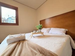 a bedroom with a large bed with a wooden headboard at Apto Rua Coberta Gramado in Gramado