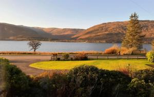 a park with a bench in front of a lake at The Hideaway Guest suite in Fort William