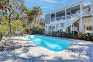 a swimming pool in front of a house at Jungle House-Heated Pool-Pet Friendly-Luxury in Edisto Island