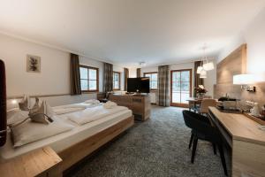 a large bedroom with a large bed and a desk at Hotel Neuhäusl - herzlich familiär in Berchtesgaden +81 photos