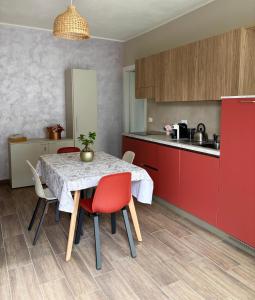 a kitchen with a table with red cabinets and red chairs at NessunConfine Casa Laura in Santa Giuletta +26 photos