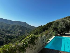a swimming pool with a view of a mountain at House in Paradise in Moneglia