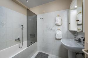 a white bathroom with a sink and a shower at Flora Beach House in Kremasti +18 photos
