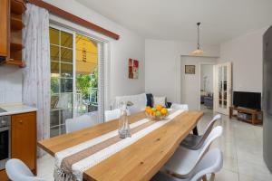 a kitchen and dining room with a wooden table and chairs at Flora Beach House in Kremasti